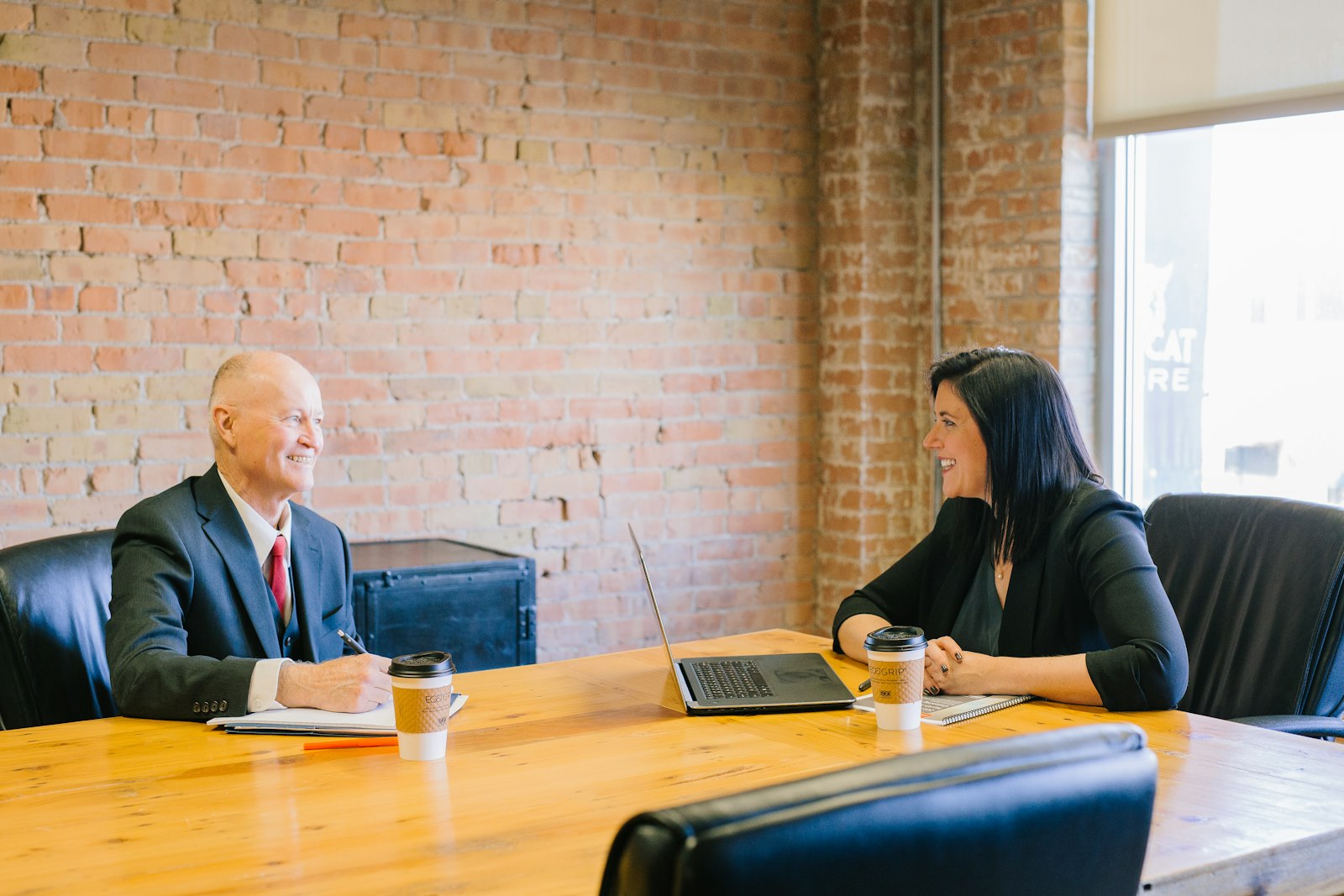 Two professionals in discussion at an office table