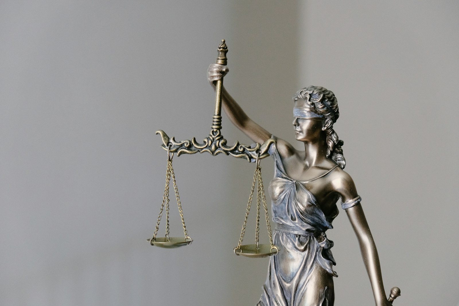 Bronze statue of Lady Justice holding balance scales
