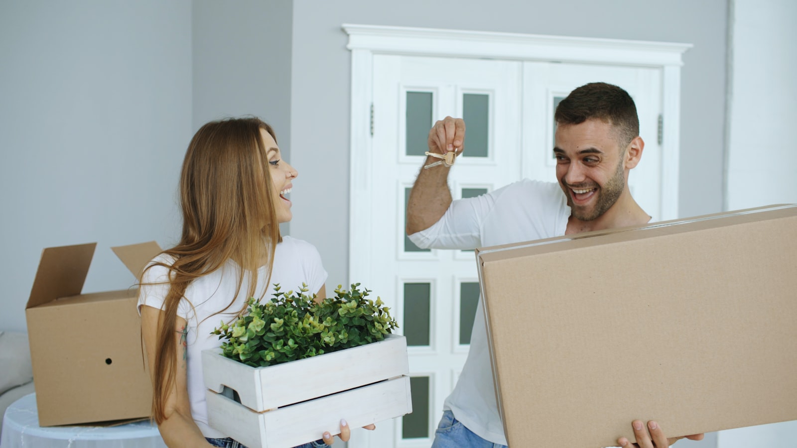 A couple standing together in an unfurnished new home